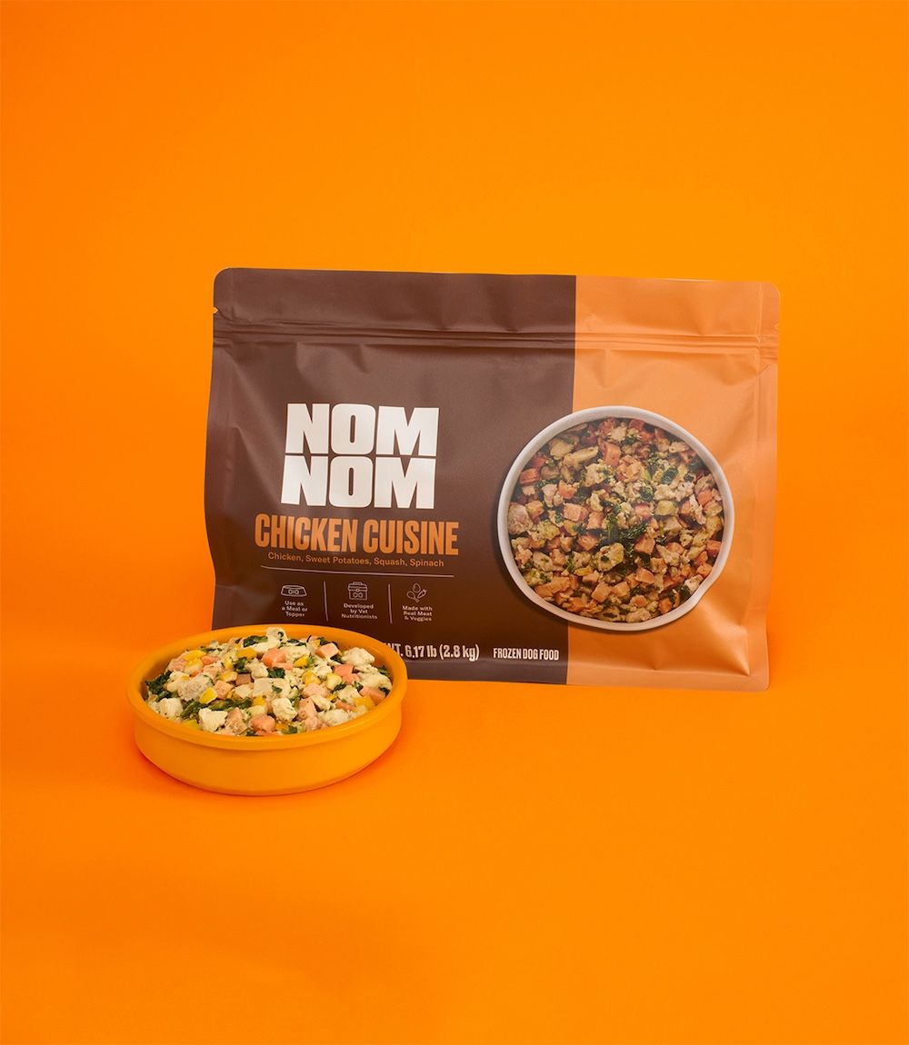 A dog eats a Chicken Cuisine meal from a bowl