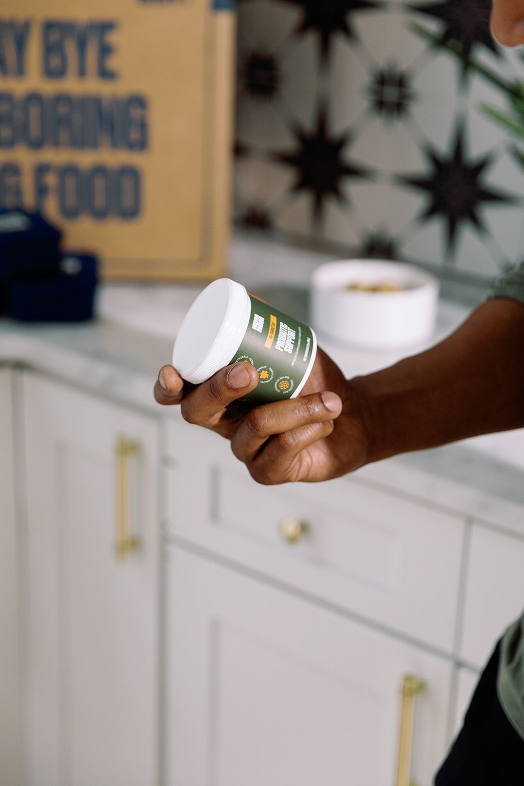 A hand holding a GI-Targeted Probiotic container