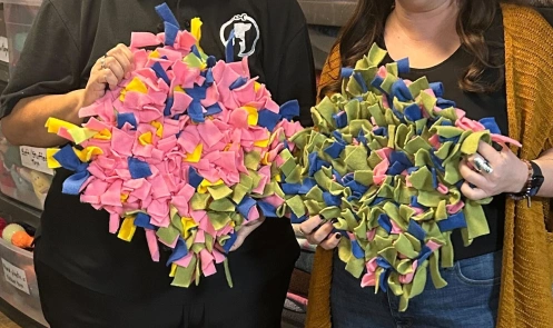 Two people hold snuffle mats