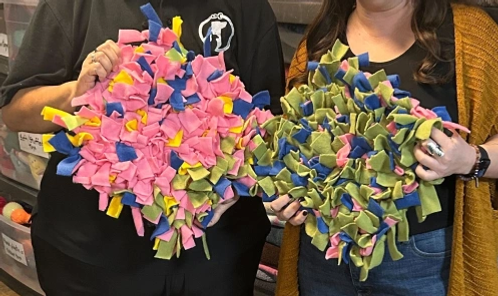 Two people hold snuffle mats