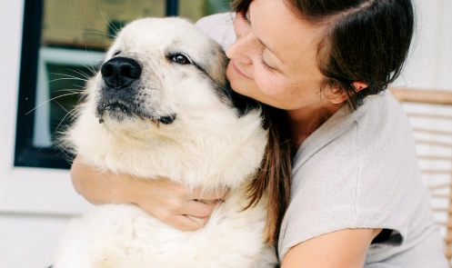A woman holding her fluffy dog