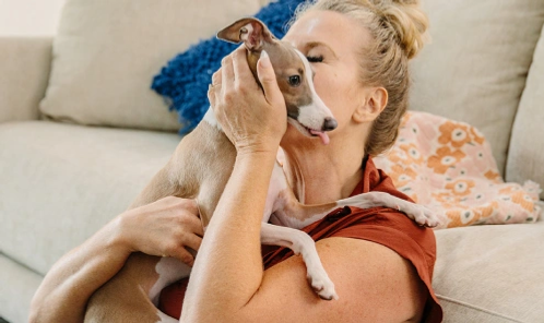 Woman cuddling her greyhound